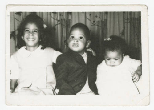 [Three young children seated indoors]