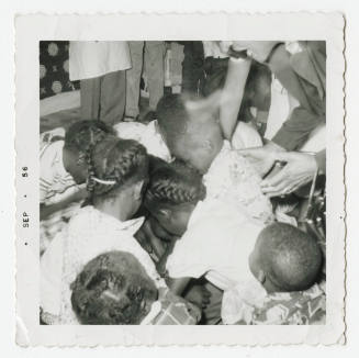 [Group of children looking down, photographed from above]