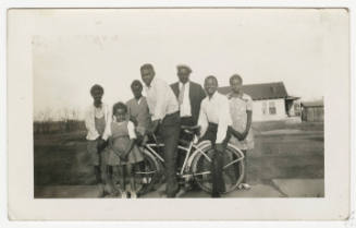 [Family standing outside with bicycle]