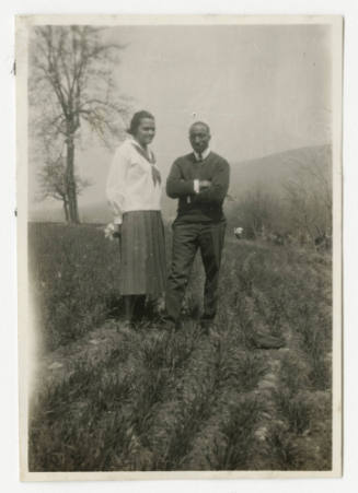 [Woman and man standing outside in a field]
