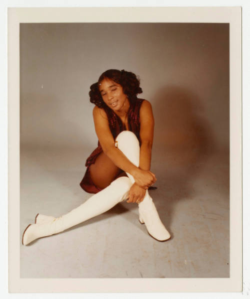 [Girl wearing white boots posed in a studio]