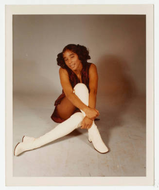 [Girl wearing white boots posed in a studio]