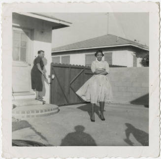 [Two women outside of a house]