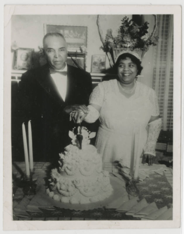 [Man and woman cutting wedding cake]