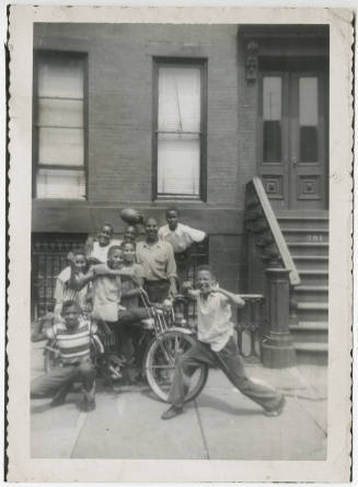 [Group of boys standing in front of a brownstone]