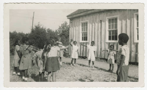 [Group of children playing next to a school building]