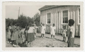 [Group of children playing next to a school building]