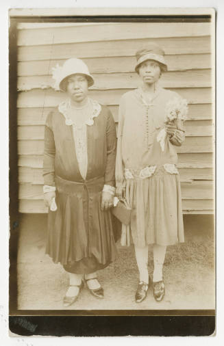 [Two women standing in front of a building]