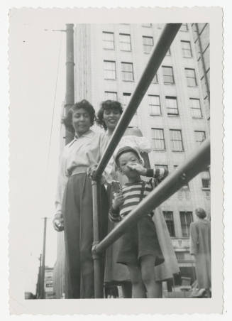[Two young women and a boy in a city]