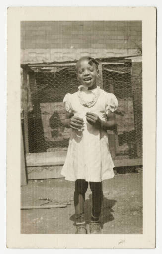 [Child standing on front of a building]