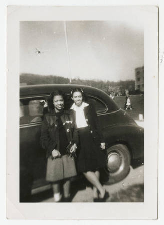 [Two women standing in front of a car]