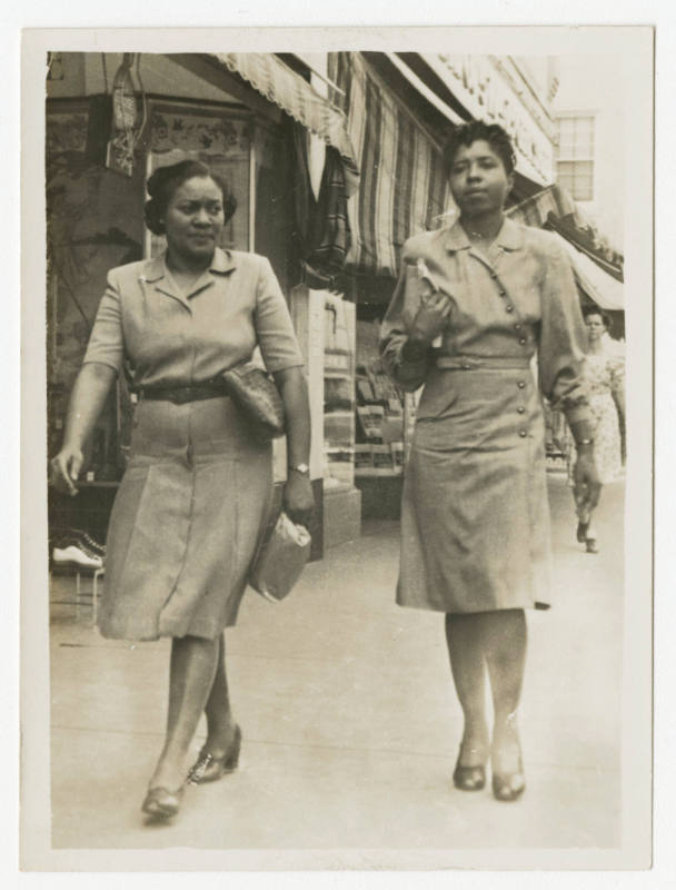 [Two women walking on a sidewalk]