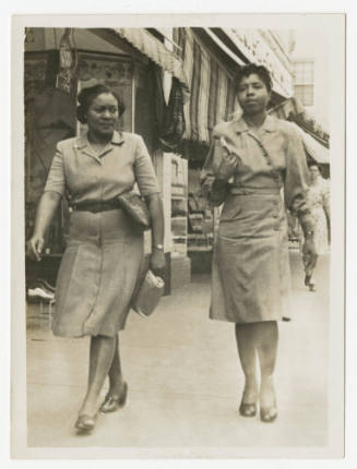 [Two women walking on a sidewalk]