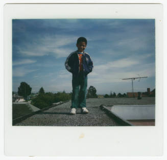 [Young boy standing on rooftop]