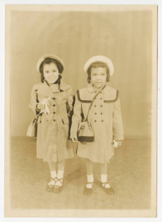 [Two young girls posed in a studio]