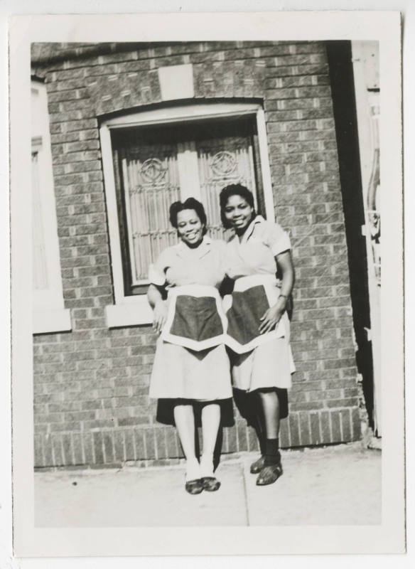 [Two waitresses standing outside]