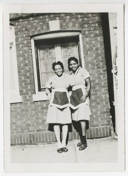 [Two waitresses standing outside]