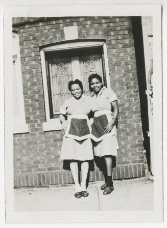 [Two waitresses standing outside]
