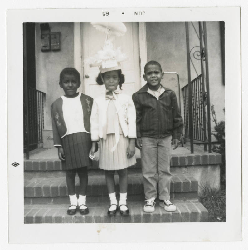[Three children standing on steps]