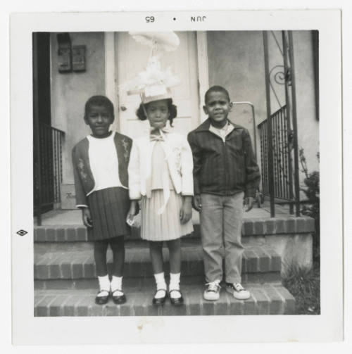 [Three children standing on steps]