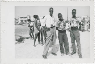 [Three men at a beach]