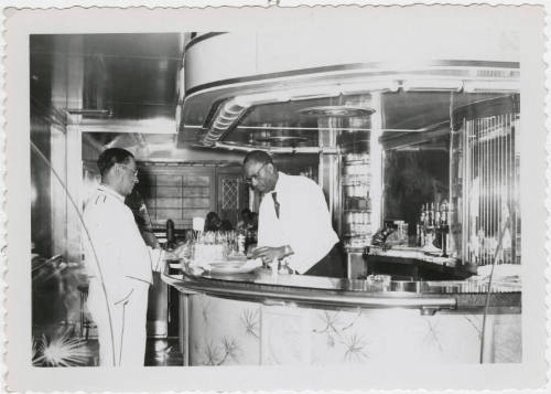[Two men working in a bar]
