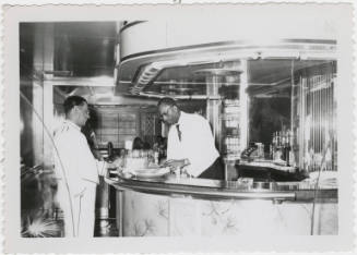 [Two men working in a bar]