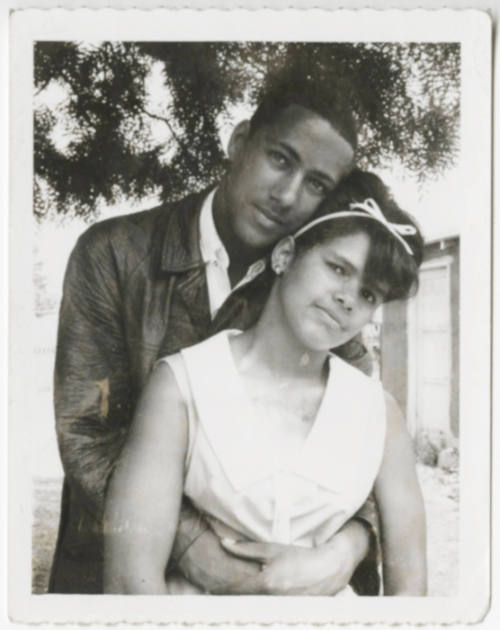 [Young couple posing outdoors]