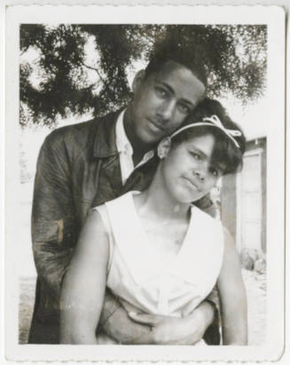 [Young couple posing outdoors]