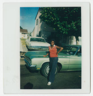 [Young woman leaning against a Buick LeSabre]